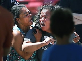 A 2-year-old boy suffered serious injuries after being run over by a car on Brock Street near Baby Street on Thursday, July 30, 2015, in Windsor, Ont. The accident occurred at approximately 3 p.m. Family members including the toddler's grandmother Ilene Senior, left, and the child's mother, right, are overcome with emotion at the scene.  (DAN JANISSE/The Windsor Star)