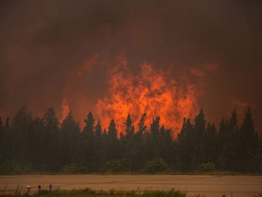 In this July 5, 2015 photo, flames ride from a wildfire near La Ronge, Saskatchewan. Canadian soldiers arrived Tuesday, July 7 to help battle raging wildfires where about 13,000 people have been evacuated in recent days. (Corey Hardcastle/Ministry of the Environment/Government of Saskatchewan via AP)