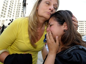 Cheryl Blades, left, of Waterford, hugs a woman who asked not to be identified after the sentencing. The woman was treated by Fata while she was pregnant twice and is still treated for an unknown condition. Thus far, her children are healthy. Blades' mother, Nancy LaFrance, died of lung cancer.  Victims and the family members of victims are emotional as they leave the federal courthouse in Detroit, Friday, July 10, 2015, after they listen to the 45-year sentencing of Dr. Farid Fata for misdiagnosis of cancer and Medicare fraud. (Todd McInturf/Detroit News via AP)