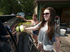 Darla McLennan and her mother, Robin McLennan, left, wash down a pick-up truck at a car wash fundraiser at the Colchester Eatery, Saturday, July 11, 2015.  Funds raised will go to Griefworks, a program run through the Canadian Mental Health Association.  (DAX MELMER/The Windsor Star)