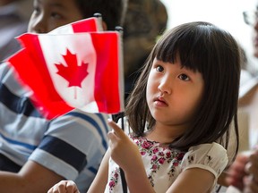 Joanna Lin, 4, holds on to her Canadian flags after becoming a Canadian citizen at a Citizen swearing-in ceremony at the Windsor International Aquatic and Training Centre, Wednesday, July 1, 2015.  (DAX MELMER/The Windsor Star)