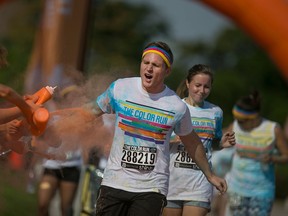 People participate in the Color Run along Windsor's waterfront, Saturday, July 18, 2015.  Participants run a 5km course along the riverfront while being sprayed with coloured dye.  (DAX MELMER/The Windsor Star)