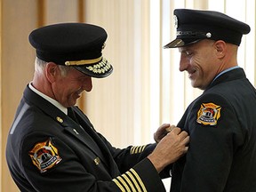 Fire Chief Bruce Montone pins a badge on Steven Weiler and the rest of the newest firefighters to join the Windsor Fire Department during the recruit graduation ceremony at the Caboto Club in Windsor on Thursday, July 2, 2015. Twelve recruits graduated a received their new postings.                      (TYLER BROWNBRIDGE/The Windsor Star)