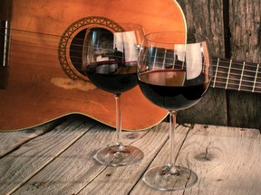 Guitar and wine on a wooden table. Photo by fotolia.com