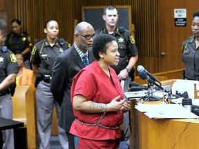 Mitchelle Blair is surrounded by Wayne County Sheriff's deputies and commanders as she addresses the court before her sentencing, Friday, July 17, 2015, in Detroit. Declaring a "house of horrors" closed, a judge sentenced the Detroit mother to life in prison Friday for killing two of her four children and storing their bodies for years in a home freezer. (Todd McInturf/Detroit News via AP)