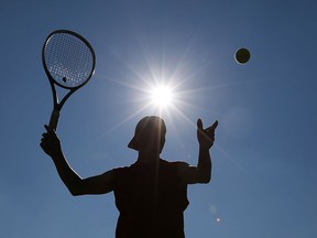 Mike Bronkowski from Southwestern Tennis Services sets up to return the tennis ball under a hot sun during a workout at Central Park in Windsor, Ontario on July 27, 2015.   Hot and humid weather will dominate the region through Wednesday. (JASON KRYK/The Windsor Star)