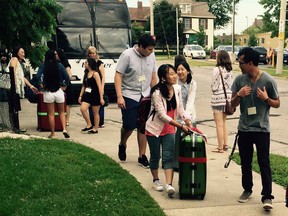 Volunteers welcome high school students from Windsor's sister city of Fujisawa, in Japan, on their arrival in Windsor on Sunday, July 26, 2015. The students will stay in Windsor for a two-week cultural and language immersion program. Local families will host the students, who will take English and history classes, and visit local and regional attractions. (CHRIS THOMPSON/The Windsor Star)