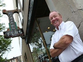 Lazare's & Co owner Paul Twigg is seen with the classic Lazare's Furs sign in Windsor on Monday, July 13, 2015.                         (TYLER BROWNBRIDGE/The Windsor Star)