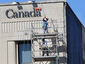 Workers assemble scaffolding on the Paul Martin Building in downtown Windsor, ON. on Thursday, July 23, 2015.