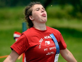 Megan Ankrapp, 15, from Buchanan, Mich., lets loose a 49 foot, 1/4 inch spit to win the women's category during the 42nd International Cherry Pit-Spitting Championship at Tree-Mendus Fruit Farm in Eau Claire, Mich., on Saturday, July 4, 2015.  (Ron DeKett/The Herald-Palladium via AP)