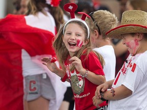 Cousins, Sabrina Kanni, 7, left, and Jayden Bartlett, 7, share a laugh while enjoying the Canada Day Parade, Wednesday, July 1, 2015.  (DAX MELMER/The Windsor Star)