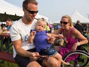 Mike, left, Alyssa and Jenn Belawetz enjoy their food at Ribfest in Amherstburg on Saturday, July 4, 2015. (JESSELYN COOK/The Windsor Star)