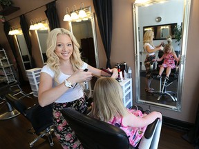Sarah Nicholson, left, curls the hair of Rylie-Rie Rochon, 4, at her hairdressing shop at 4281 Wyandotte Street East in Windsor, Ontario on July 24, 2015. (JASON KRYK/The Windsor Star)
