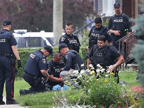 Windsor police are shown on Thursday, July 9, 2015, in the 1400 block of Windermere Road during a standoff with a man in a house. Officers arrest the man after he exited the house. (DAN JANISSE/The Windsor Star)
