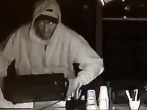 A suspect is seen wrenching the cash register away from the counter at Salute Espresso Bar on July 4, 2015. (Courtesy of Salute Espresso Bar)