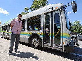 Kieran McKenzie is shown next to a Transit Windsor bus on Tuesday, July 21, 2015, on Ouellette Ave. in Windsor, ON. He is part of a group that is challenging local citizens and politicians to take the public transit challenge. (DAN JANISSE/The Windsor Star)