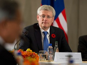 Prime Minister Stephen Harper listens to United States President Barack Obama deliver opening remarks to members of the Trans Pacific Partnership at the US Embassy in Beijing, China, on Monday, November 10, 2014. THE CANADIAN PRESS/Adrian Wyld