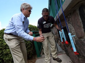 Derek Locke filters a glass of Detroit River water for Wayne Titus, left, at Dieppe Park in Windsor on Tuesday, August 4, 2015. The Rotary Club was there to demonstrate their Shelter Box and raise awareness of what the Rotary Club does. (TYLER BROWNBRIDGE/The Windsor Star)