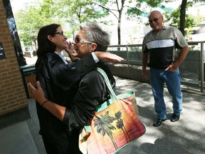 Lawyer Sharon Strosberg, left, hugs Dee Lawton as Stan Lawton looks on outside Superior Court in Windsor on Wednesday, August 12, 2015. (TYLER BROWNBRIDGE/The Windsor Star)