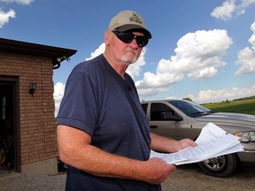 Ted Richardson of South Malden Road wants no part of wind turbines August 11, 2015. He is especially annoyed at language in a option agreement proposal from GDF Suez Canada, a wind turbine company.  He received the option agreement earlier this year. "Get away from these things as fast as possible," he said.  (NICK BRANCACCIO/The Windsor Star)