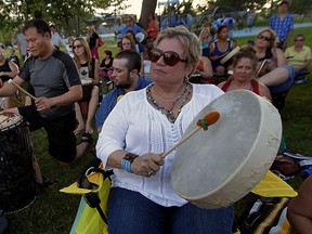 On a beautiful summer evening, Nelson Ing, left, and Nancy Kelly, right, perform with about 150 drummers, many from White Feather Holistic Arts, during a full blue moon drum circle at Lanspeary Park Friday Friday July 31, 2015. (NICK BRANCACCIO/The Windsor Star)