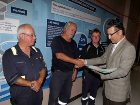 A.H. Weeks Water Treatment plant workers Andre Gagnon, left, Dennis Meyer and Wayne White and their co-workers were honoured with EnWin Gold Star Certificates by Garry Rossi, EnWin director of water production, Thursday August 12, 2015. The Windsor Utilities Commission and EnWin were recently given industry awards for their innovative approach in water technology. (NICK BRANCACCIO/The Windsor Star)