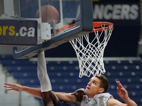 University of Windsor's Alex Campbell appears to have lost his head during layup against  University of Indianapolis forward Jack Brody during men's basketball action at the St. Denis Centre in Windsor, Ontario on August 20, 2015. (JASON KRYK/The Windsor Star)