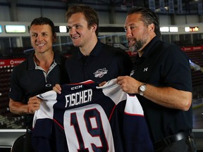 Christian Fischer, centre, is given a Spitfires Jersey by head coach Rocky Thompson, left, and GM Warren Rychel during a press conference at the WFCU Centre in Windsor on Monday, August 24, 2015. (TYLER BROWNBRIDGE/The Windsor Star)