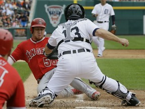 Los Angeles Angels' Kole Calhoun safely beats the tag of Detroit Tigers catcher Alex Avila to score from second on a single by teammate Albert Pujols during the sixth inning of a baseball game Thursday, Aug. 27, 2015, in Detroit. (AP Photo/Carlos Osorio)