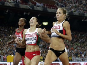 Belarus' Marina Arzamasova, center, crosses the line to win the gold medal in the women's 800m final ahead of Canada's Melissa Bishop, silver, and Kenya's Eunice Jepkoech Sum, bronze, at the World Athletics Championships at the Bird's Nest stadium in Beijing, Saturday, Aug. 29, 2015. (AP Photo/Andy Wong)