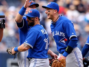 Kevin Pillar centre, and Troy Tulowitzki, right, of the Toronto Blue Jays celebrate with Justin Smoak after their win over the New York Yankees on August 8, 2015 at Yankee Stadium in New York City.The Toronto Blue Jays defeated the Yankees 6-0. (Photo by Elsa/Getty Images)