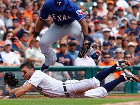 Detroit's Ian Kinsler, bottom, slides into third base as Adrian Beltre of the Texas Rangers attempts to make the play during the first inning on August 23, 2015 at Comerica Park in Detroit, Michigan. (Photo by Leon Halip/Getty Images)
