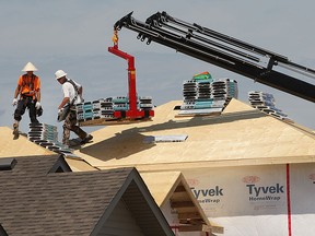 Workers unload shingles at the construction site of a new home in the 1000 block of Ivanhill Avenue on Friday, Aug. 7, 2015, in Windsor, Ont. Residential building permits are up for the first time in years. (DAN JANISSE/The Windsor Star)