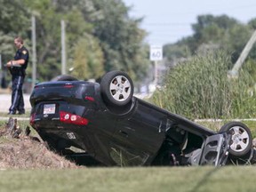 A car rests on the grass after a rollover accident on County Road 27, just north of Lions Club Road on Sunday, Aug. 23, 2015. (DAX MELMER/The Windsor Star)