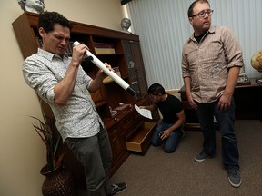 Members of The Windsor Star's news staff search for clues as they try to escape The Professor's Office at Enigma Escape Rooms on Aug. 20, 2015. (Tyler Brownbridge / The Windsor Star)