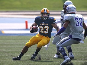 Windsor running back, Jaydon Gauthier, left, is chased down by Western's Josh Woodman (32) and Jean-Gabriel Poulin (10) during the Windsor Lancers season opener at Alumni Field, Sunday, August 30, 2015.  (DAX MELMER/The Windsor Star)