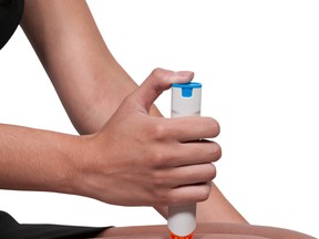 Woman injecting emergency medicine (EpiPen) into her leg. Photo by fotolia.com