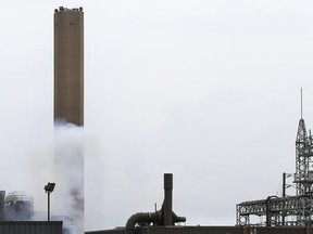 Smoke is shown at the bottom of the former General Motors smokestack on Monday, August 10, 2015, in Windsor, ON. after the third unsuccessful implosion attempt of the day. (DAN JANISSE/The Windsor Star)