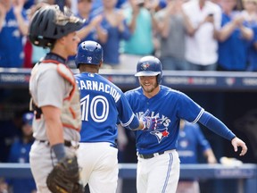 Blue Jays' Josh Donaldson, right, and Edwin Encarnacion, centre, celebrate Encarnacion's two-run home run in front of Detroit Tigers catcher James McCann during the sixth inning in Toronto on Saturday, August 29, 2015. THE CANADIAN PRESS/Darren Calabrese