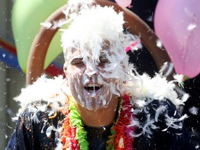 Jonathon Azzopardi, president of LAVAL International in Maidstone, Ont., gets covered with feathers in a fundraiser benefiting United Way Windsor-Essex County on Thursday, Aug. 8, 2015. Employees participated in a food auction where they purchased food items to dump on Azzopardi and LAVAL International's accounting manager Grant Maguire.  (DYLAN KRISTY/The Windsor Star)