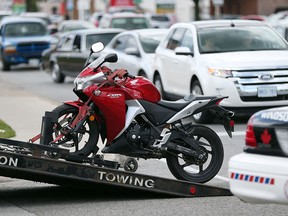 A motorcycle is loaded on a tow truck following an accident involving a motorcycle and a car on Tecumseh Road east and Jos. St. Louis Aveue in Windsor, Ontario on August 4, 2015.  Windsor Police, Windsor Fire Service and Essex-Windsor EMS paramedics responded to the scene.  At least one person was transported to hospital with unknown injuries.    Windsor Police were investigating a possible hit-and-run accident - but officer on scene didn't confirm.  (JASON KRYK/The Windsor Star)