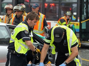 File photo of EMS and firefighters working to remove one of two victims in a car that was involved in a collision with a Transit Windsor bus at he Corner of Erie Street and Goyeau Street in Windsor on Monday, Aug. 10, 2015. Three people were transported to hospital with non-life threatening injuries.                         (TYLER BROWNBRIDGE/The Windsor Star)