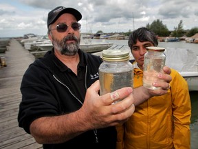 Mayor Rick Masse is shown clear water samples from Scudder Dock on Pelee Island.  Raj Gill, right, Great Lakes Organizer, Canadian Freshwater Alliance took the samples from the water near the dock. (NICK BRANCACCIO/The Windsor Star)