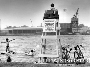 Swimmers enjoy the cool waters of the Detroit River despite a sign warning of high pollution readings at Chewitt Beach at the foot of Russell Street in Windsor on July 10, 1981. (FILES/The Windsor Star)