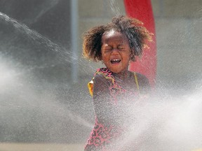 Serenity Monlyn beats the heat at the AKO Park splash pad in Windsor on Monday, Aug. 17, 2015. Temperatures soared above 30 degrees again on Monday.                          (TYLER BROWNBRIDGE/The Windsor Star)