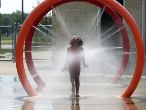 Serenity Monlyn beats the heat at the AKO Park splash pad in Windsor on Monday, Aug. 17, 2015. Temperatures soared above 30 degrees again on Monday.                          (TYLER BROWNBRIDGE/The Windsor Star)