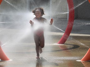 Serenity Monlyn beats the heat at the AKO Park splash pad in Windsor on Monday, Aug. 17, 2015. Temperatures soared above 30 degrees again on Monday.                          (TYLER BROWNBRIDGE/The Windsor Star)