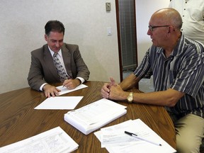 NDP candidate Brian Masse, left, signs his election paper work in front of returning officer Tom Lynd at the Elections Canada office in Windsor on Wednesday, August 19, 2015.                          (TYLER BROWNBRIDGE/The Windsor Star)