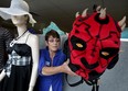 Deanne Miihlroth of Society Saint Vincent de Paul Thrift Store, prepares a back-to-school window display at the Chilver Road store Monday Aug. 17, 2015. The devilish-looking Star Wars backpack has a $4.50 price tag.  It is expected to sell quickly. (NICK BRANCACCIO/The Windsor Star)