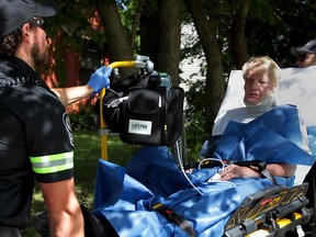 Robbery victim Keith Murphy is assisted by Essex-Windsor EMS paramedics after being allegedly robbed by several men in his apartment at 440 Prince Road Aug. 24, 2015. Murphy suffered cuts to his face, hand and leg during the incident. A large kitchen knife was found outside his apartment unit.  Multiple police cruisers responded the call. Murphy's room was ransacked according to a neighbour. (NICK BRANCACCIO/The Windsor Star)